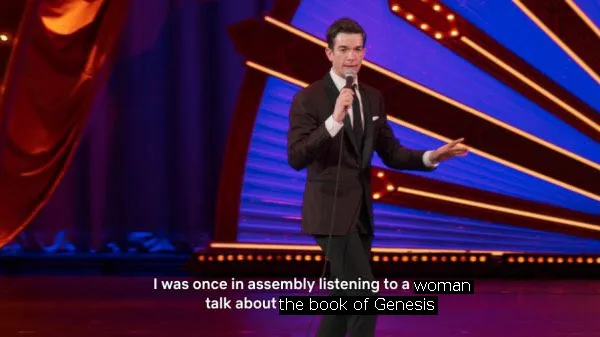 An edited screenshot of a John Mulaney special in which he's been made to say 'I was once in assembly listening to a woman talk about the book of Genesis'