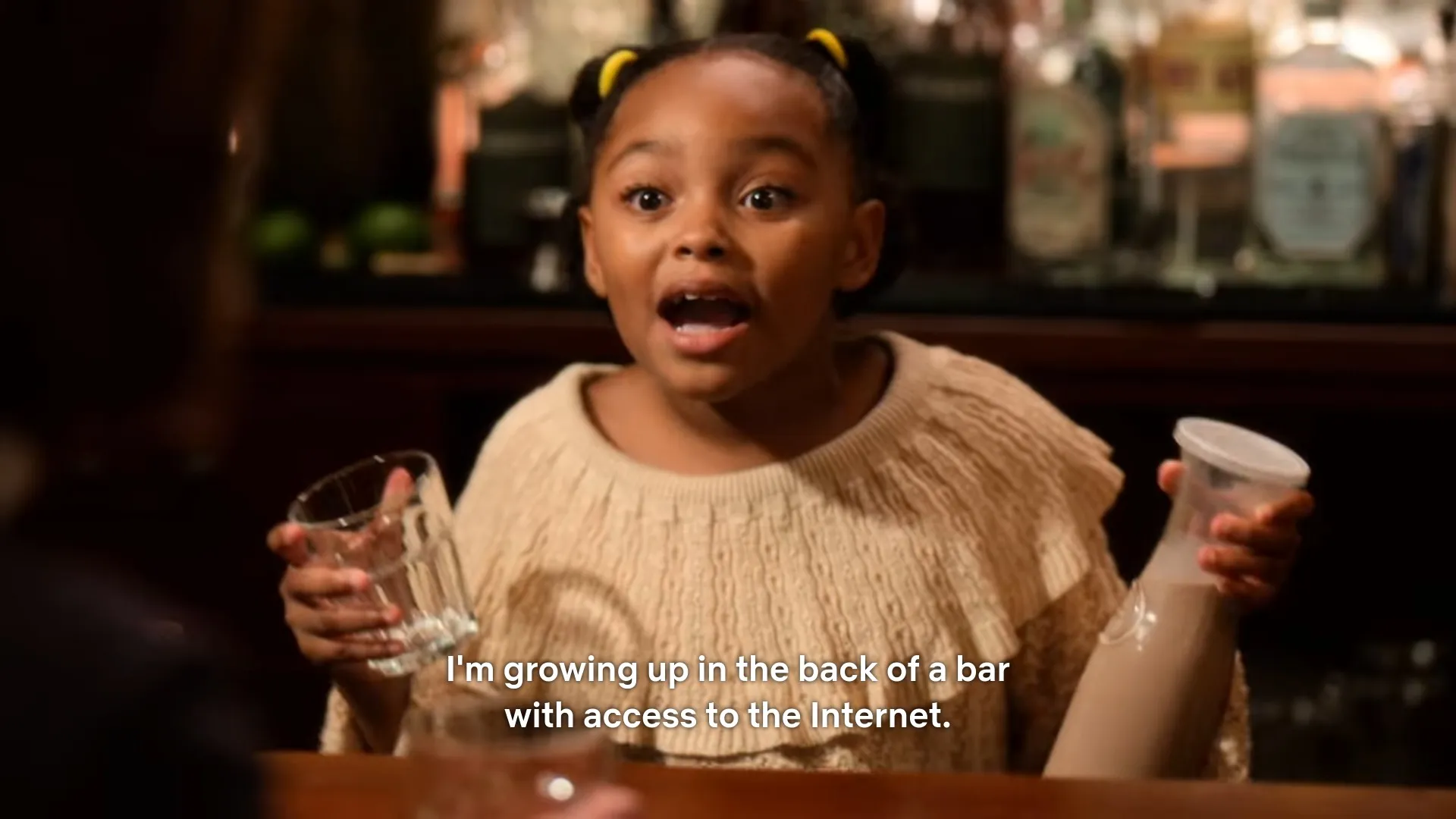 A screenshot from Christmas on the Square in which a child bartender says 'I'm growing up in the back of a bar with access to the Internet.'