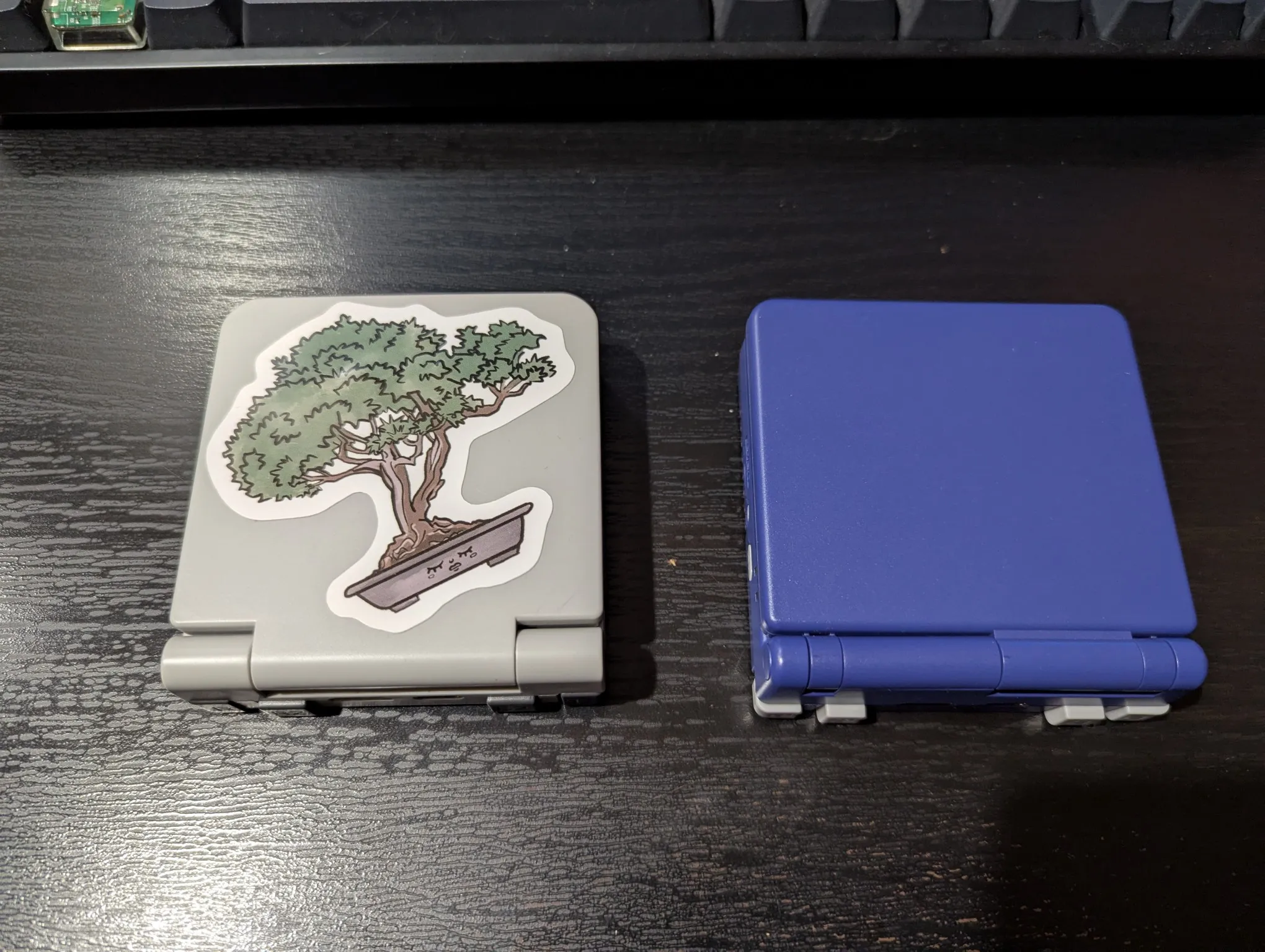 "The Miyoo Flip (right) vs. the Anbernic RG34XXSP (left). I haven't found a good sticker for the RG34XXSP but I really like the one on the Flip"